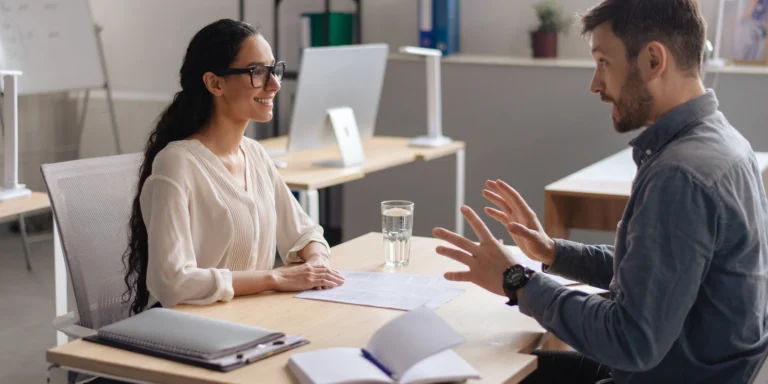 A man and a woman having a professional conversation during a reverse recruiting job interview in the UAE, showcasing proactive job search strategies.