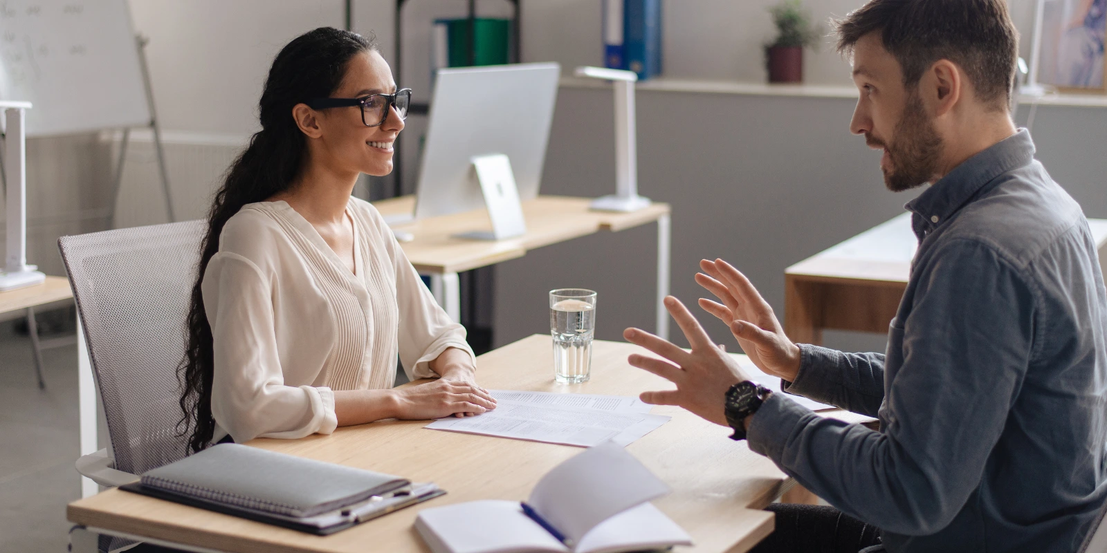 A man and a woman having a professional conversation during a reverse recruiting job interview in the UAE, showcasing proactive job search strategies.