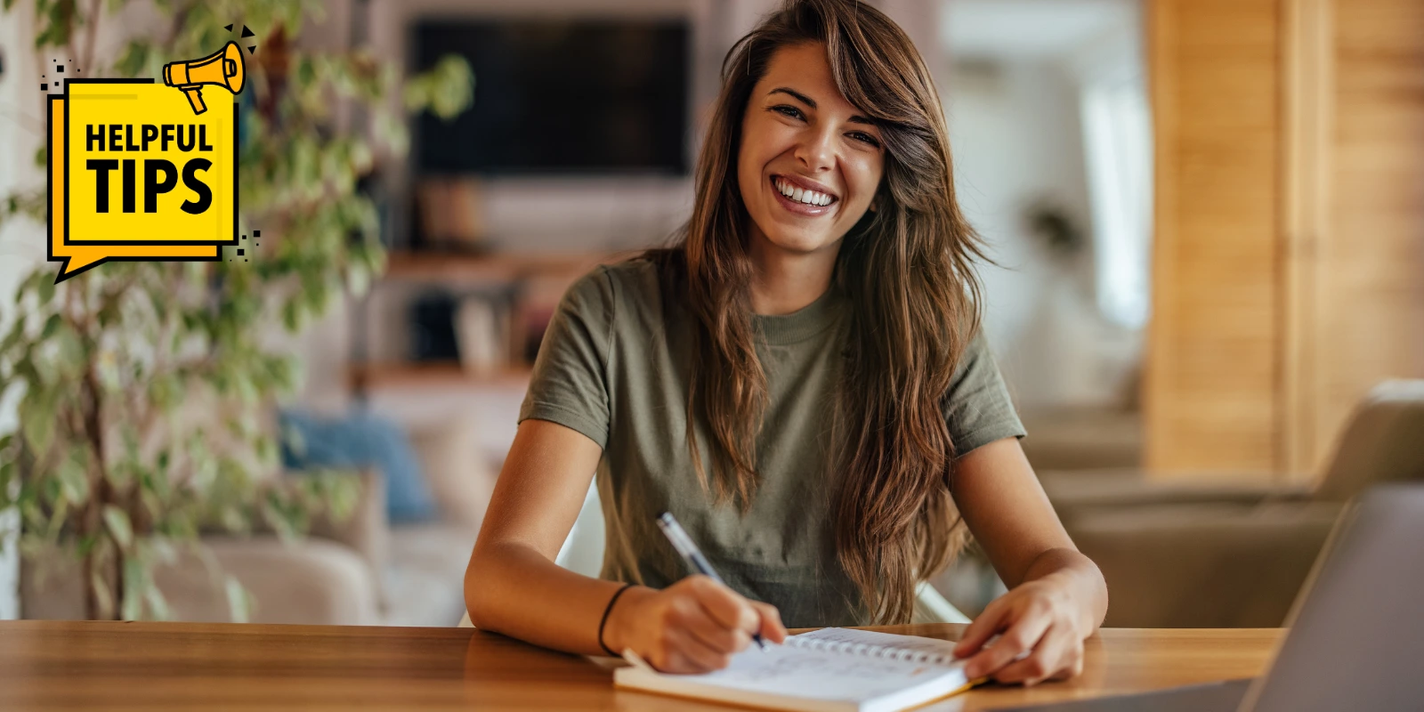 A woman smiling while writing in a notebook, showcasing helpful job hunting tips for job seekers.